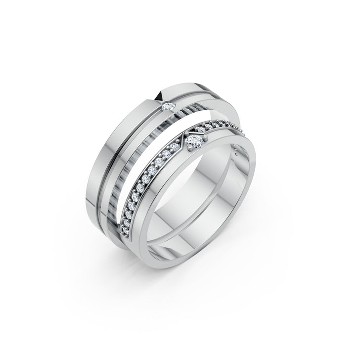 Le Cap à Deux, două verighete cu detalii discrete în V, un șir de diamante pe una și un singur diamant pe cealaltă, vedere oblică, cu inelele suprapuse, metal alb.