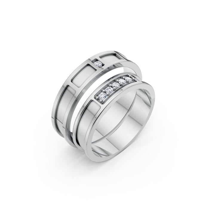 Notre Cadence, două verighete cu panouri dreptunghiulare, cinci diamante într-un șir pe una și un diamant pe cealaltă, vedere oblică, cu inelele suprapuse, metal alb.