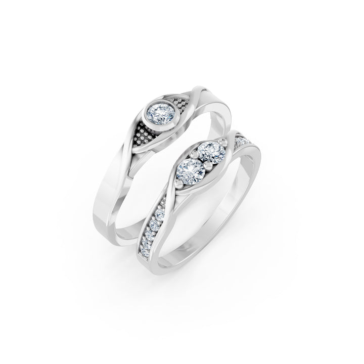 La Rencontre des Courbes, două verighete cu linii curbe încrucișate, două diamante centrale pe una și un diamant pe cealaltă, vedere oblică, cu inelele suprapuse, metal alb.
